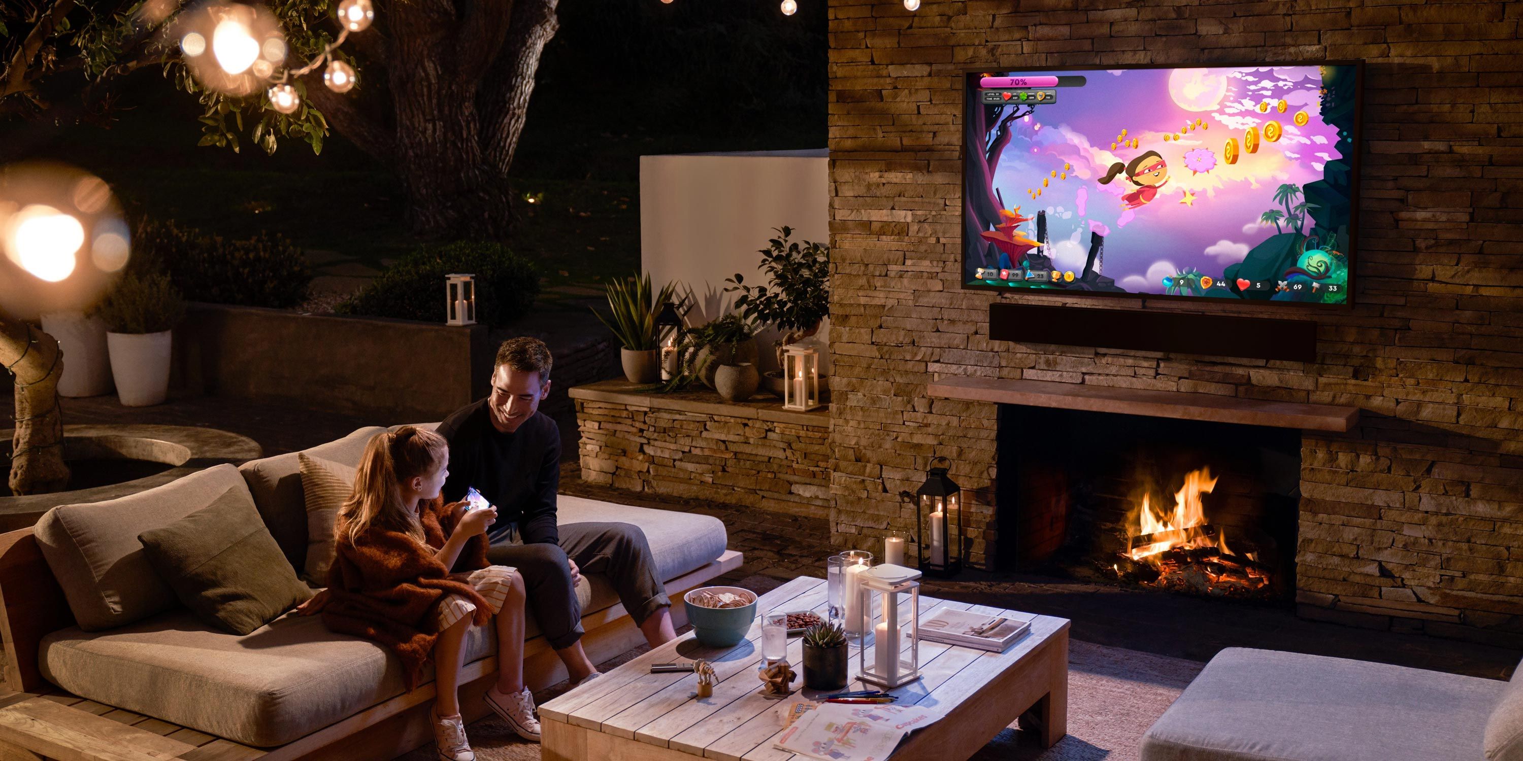 father and daughter sitting on patio in the evening playing games